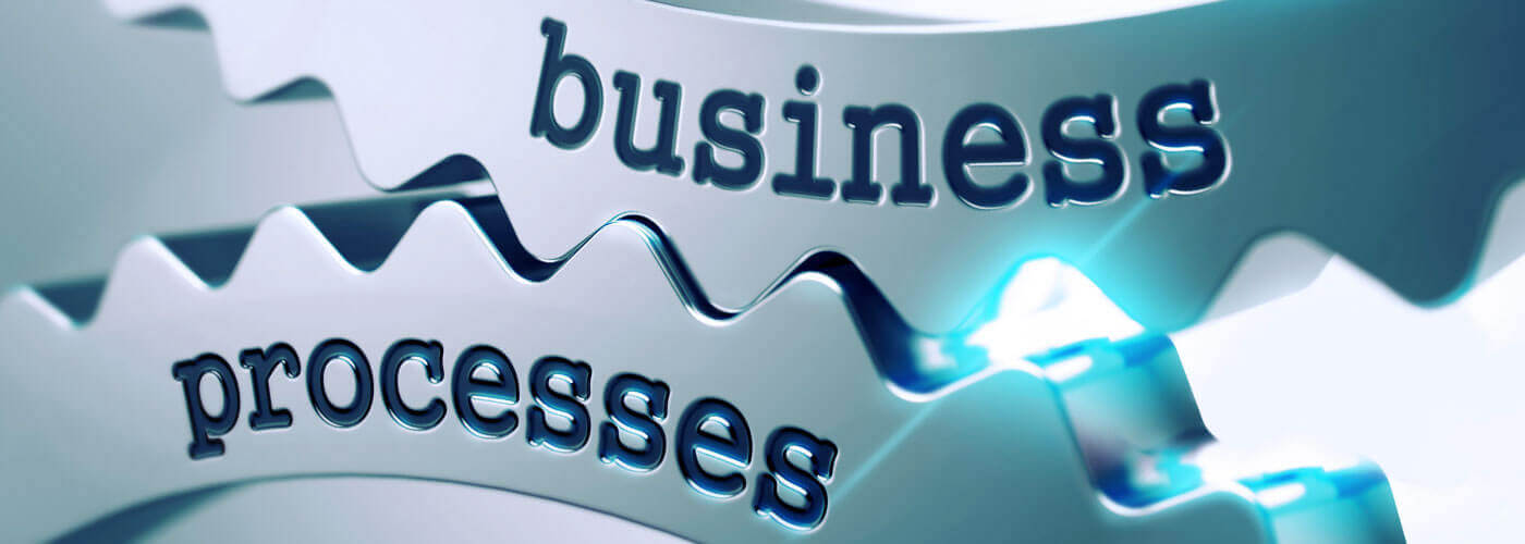 two gears grinding with the words "business" and "processes" written on them.